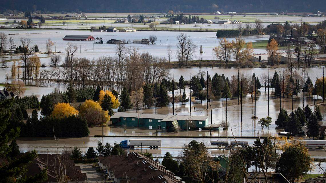 Abandoned transport trucks are seen on the Trans-Canada Highway in a flooded area of Abbotsford, British Columbia, on Tuesday, Nov. 16. Conditions at a Canadian pump station improved overnight after officials issued an evacuation order that had Whatcom residents concerned about more flooding.