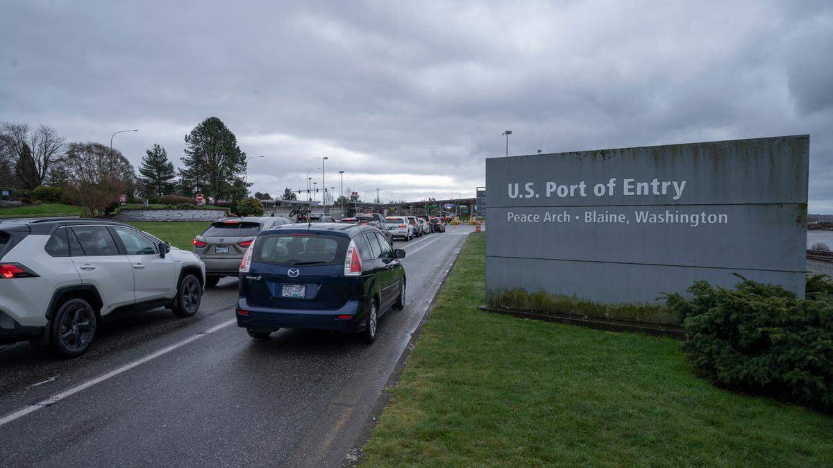 People cross the border between the U.S. and Canada at Peace Arch Park in 2022 in Blaine. A $458,000 grant to the Whatcom Council of Governments in 2023 will fund the planning phase of a cross-border project to replace the communications system that calculates wait times at the U.S.-Canada border.