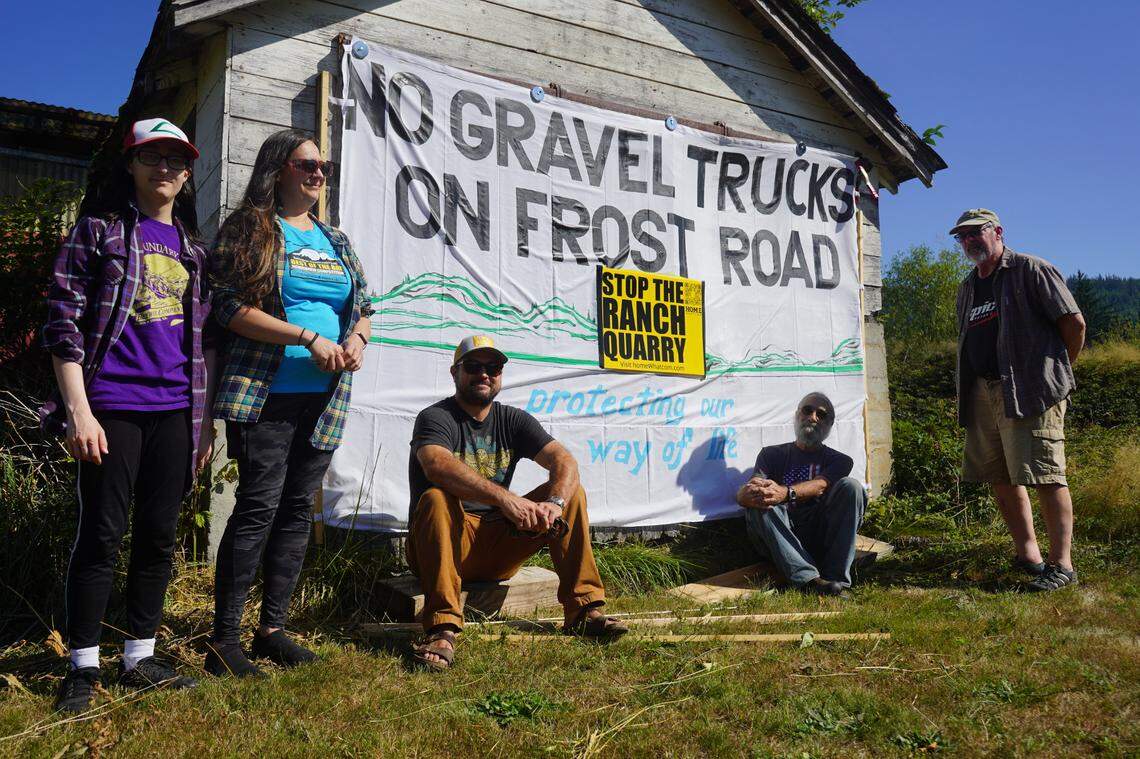 Neighbors of the proposed 64-acre rock quarry mine gathered on September 1, 2023, in front of an opposition sign along Frost Road in Whatcom County, Wash. Gravel collected from the mine could be trucked along Frost Road.
