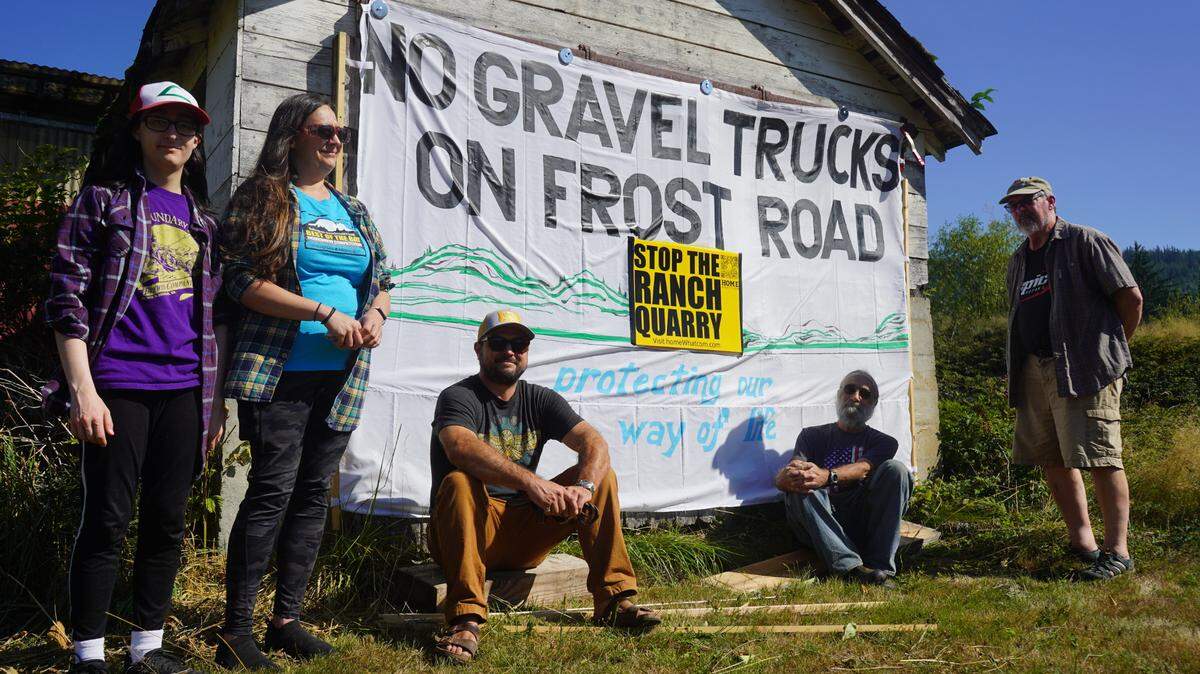 Neighbors of the proposed 70-acre rock quarry mine gather in front of an opposition sign along Frost Road in Whatcom County, Wash. The project proposes trucking the gravel along Frost Road.
