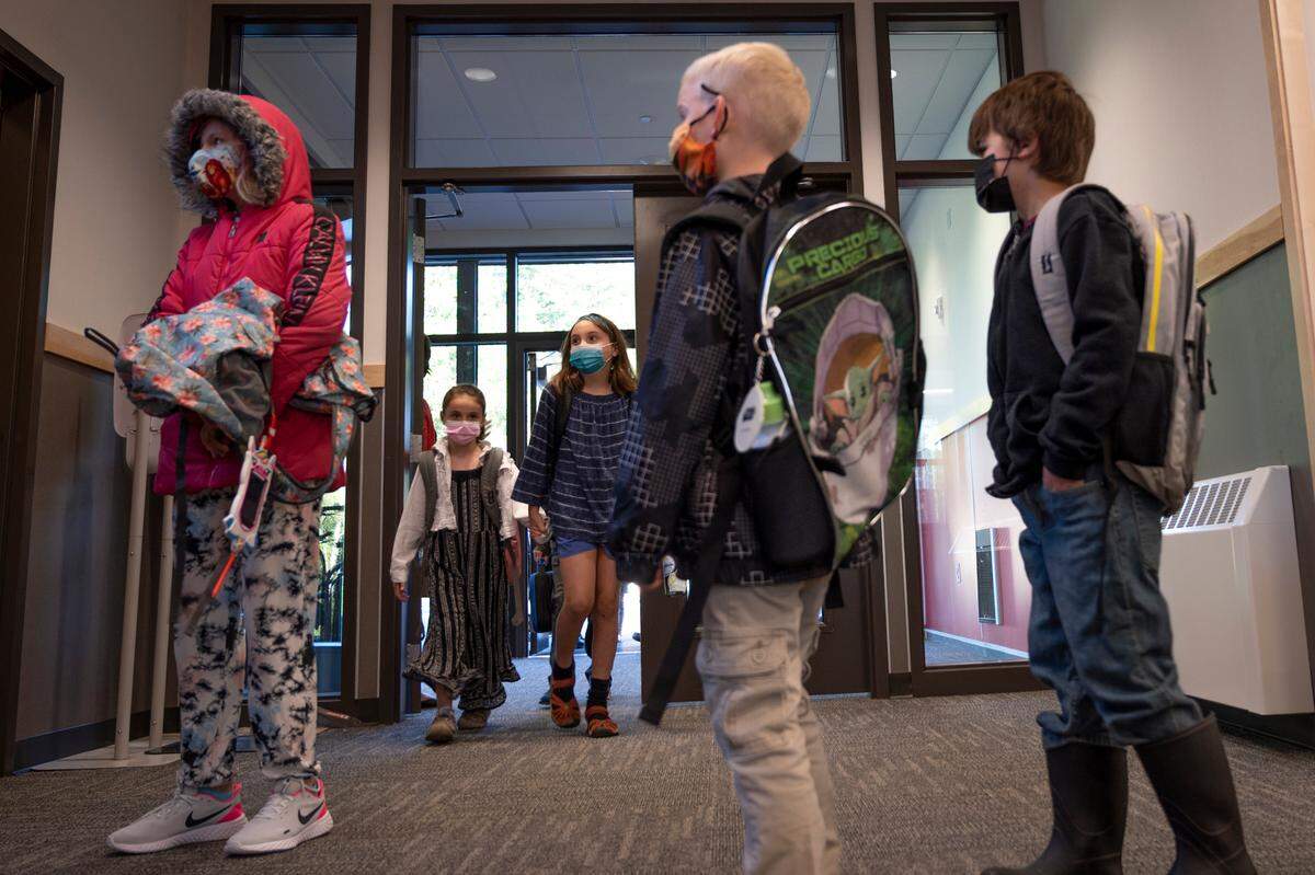 Students enter the newly built Parkview Elementary School Sept. 1, 2021, in Bellingham. With students back in person as COVID-19 surges, Washington state has mandated that masks are required for all and adults are required to have been vaccinated against COVID-19.