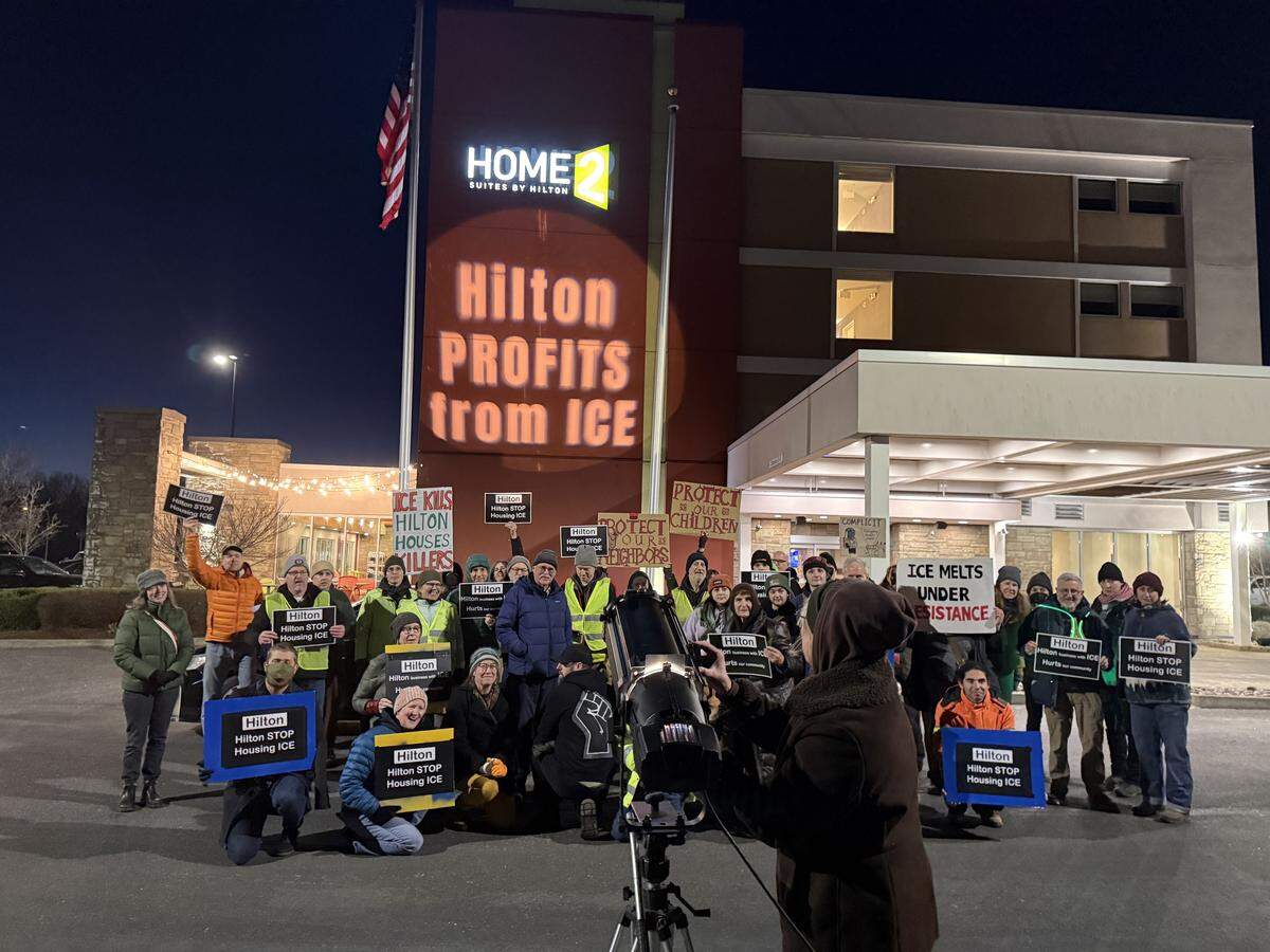 Dozens of community members gathered in front of a projection outside the Hampton Inn Bellingham Airport on Jan. 23 in Bellingham, Wash. They demanded that Hilton Hotels stop housing U.S. Immigration and Customs Enforcement (ICE) agents.