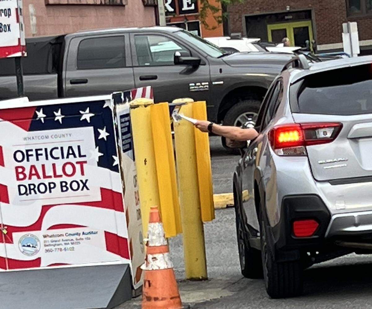 A voter leaves a primary ballot in the drop box outside the Whatcom County Courthouse in Bellingham, Wash., on Election Day, Tuesday, Aug. 6, 2024.