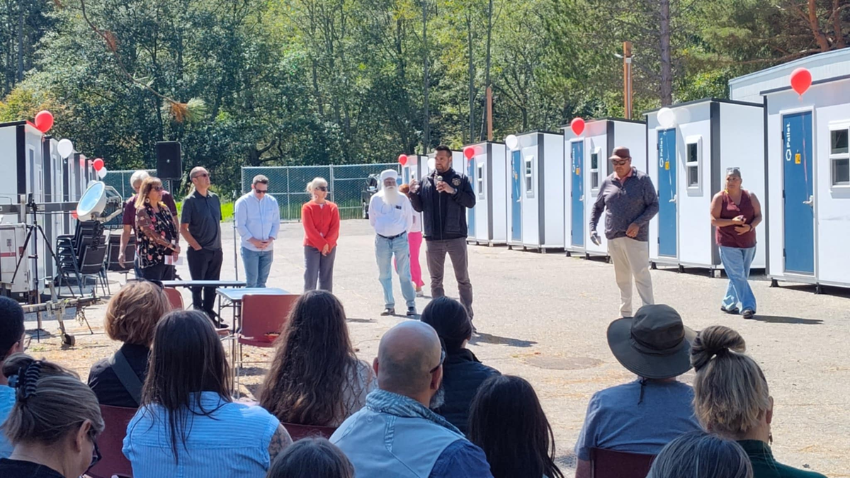 Lummi Nation Chairman Anthony Hillaire speaks at the grand opening ceremony of the Kwensot Qelat 40-unit transitional housing village for unhoused individuals on Aug. 20. Bellingham Mayor Kim Lund, Whatcom County Executive Satpal Sidhu and state Rep. Joe Timmons also provided remarks at the celebration.
