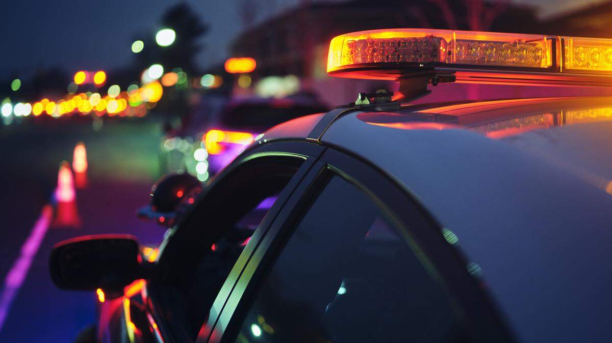 A police car stopping a vehicle at night.