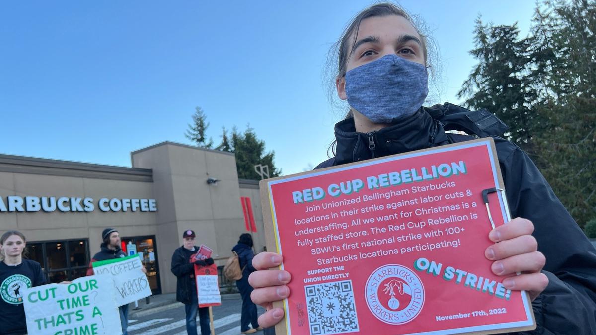 Andreas Silkiss of Bellingham, a union food worker who was also representing the group International Marxist Tendency and the Bellingham Marxist School, stands in solidarity with Starbucks pickets outside the specialty coffee chain’s location in the Sehome Village shopping center in Bellingham on Thursday, Nov. 17.