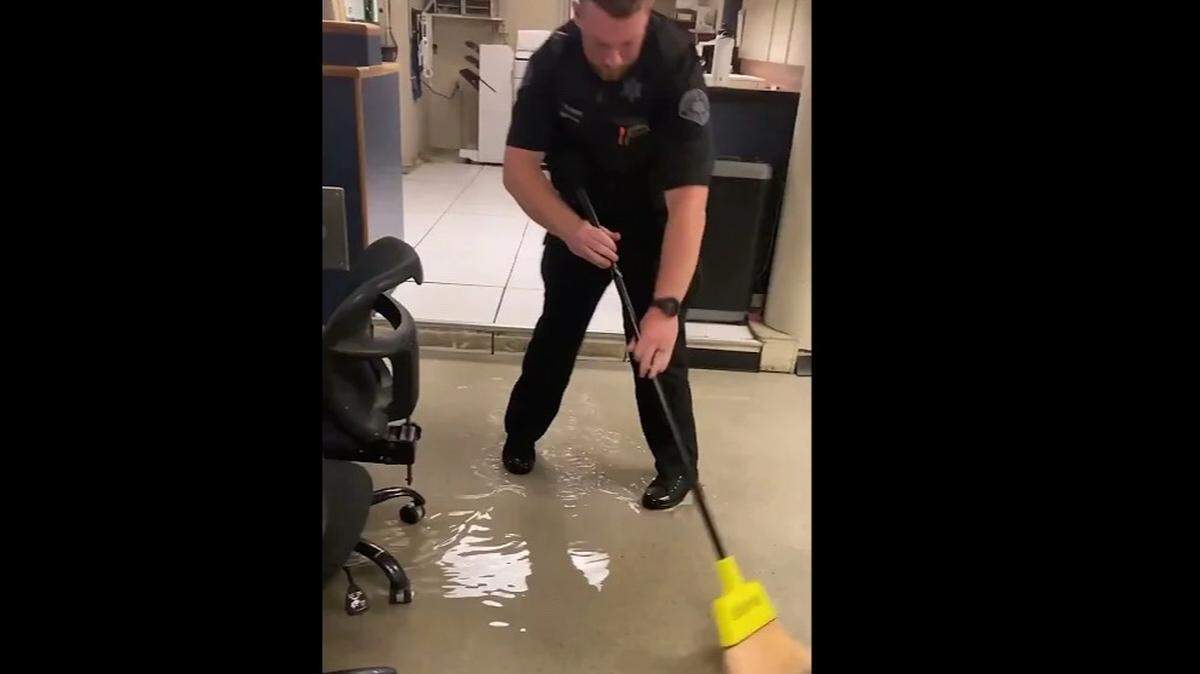 A member of law enforcement works to clear flooding at the Whatcom County Jail on Sunday, July 16, 2023, in Bellingham, Wash.