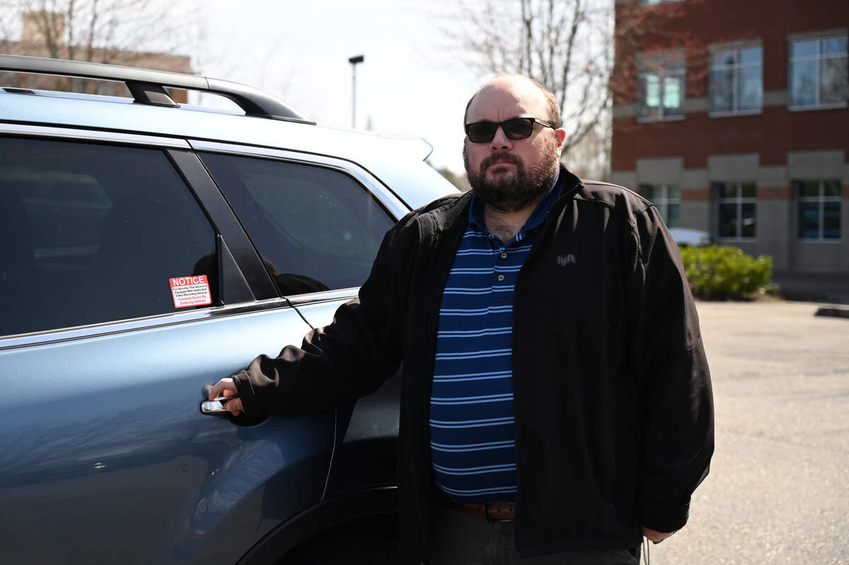 Russ Dzialo, who drives for the rideshare application Lyft, with his vehicle on Tuesday, April 6, in Bellingham.