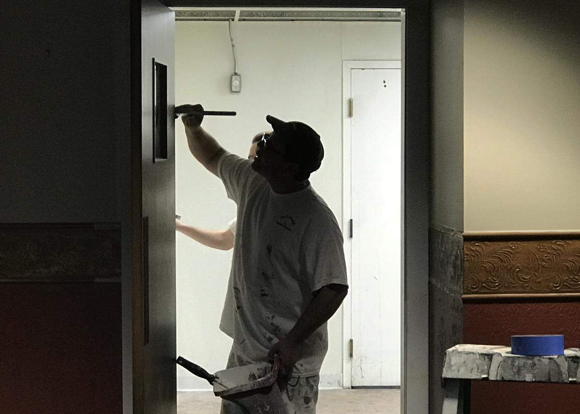 Michael Brown, a painter for Absolute Drywall and Paint, paints a doorway on the first floor of The Leopold Apartments in downtown Bellingham on Friday.