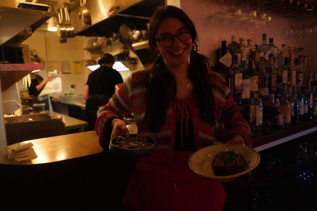 Estelle server Nadine Avella prepares to serve two dishes fresh from the kitchen on Dec. 1, 2023, in Bellingham, Wash.