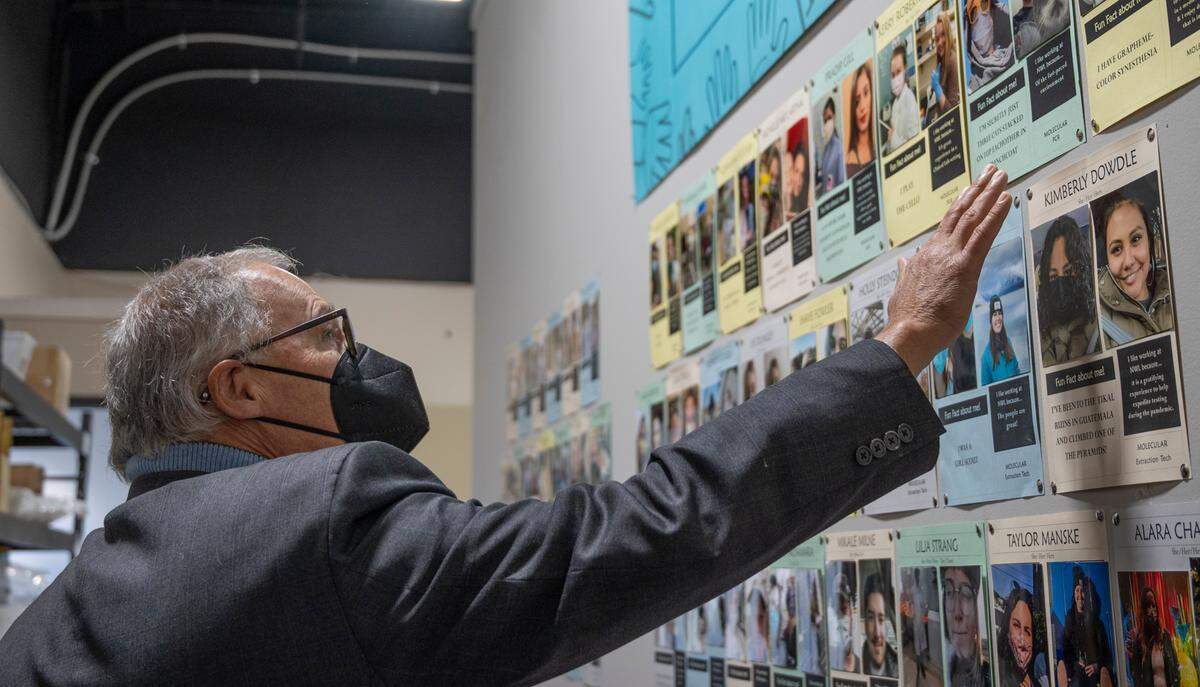 Washington state Gov. Jay Inslee admires a wall with fun facts and other information about employees at Northwest Laboratory during a visit to the testing facility on Tuesday, Oct. 12, in Bellingham.