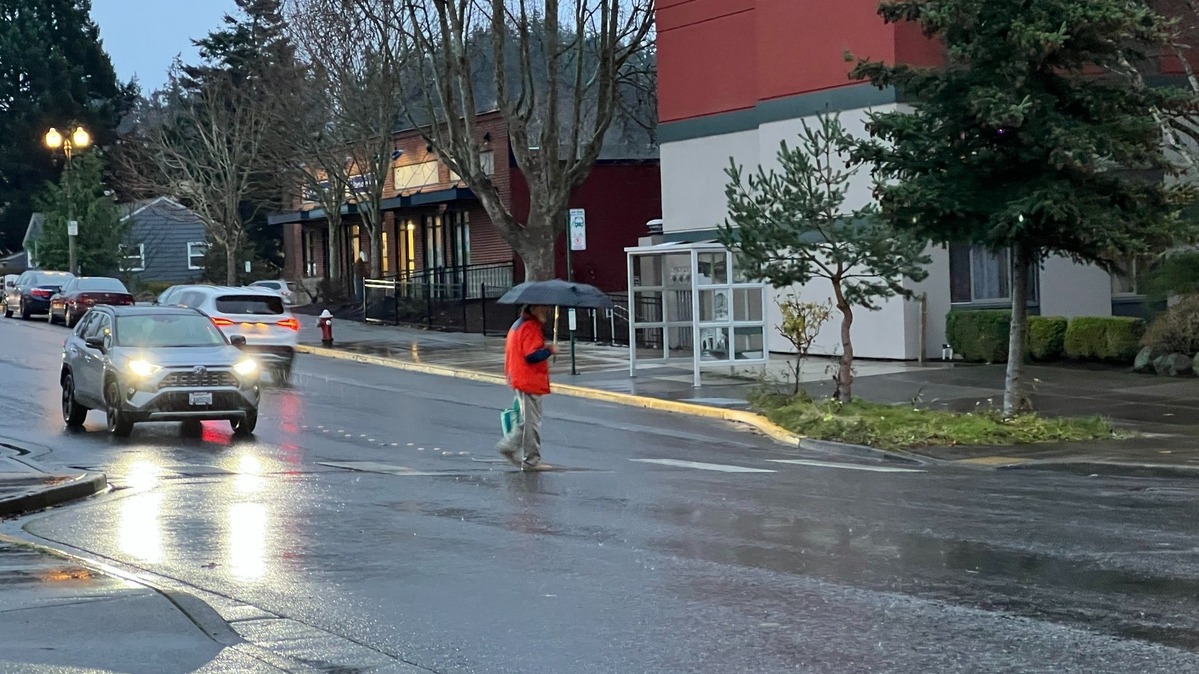 A pedestrian crosses 12th Street at McKenzie Avenue near the Haggen supermarket in the Fairhaven district of Bellingham, Wash., on Friday, Dec. 13, 2024. One car stopped for the pedestrian but a second car sped through the crosswalk. Pedestrian-activated flashing yellow lights will be added to the crosswalk next year.