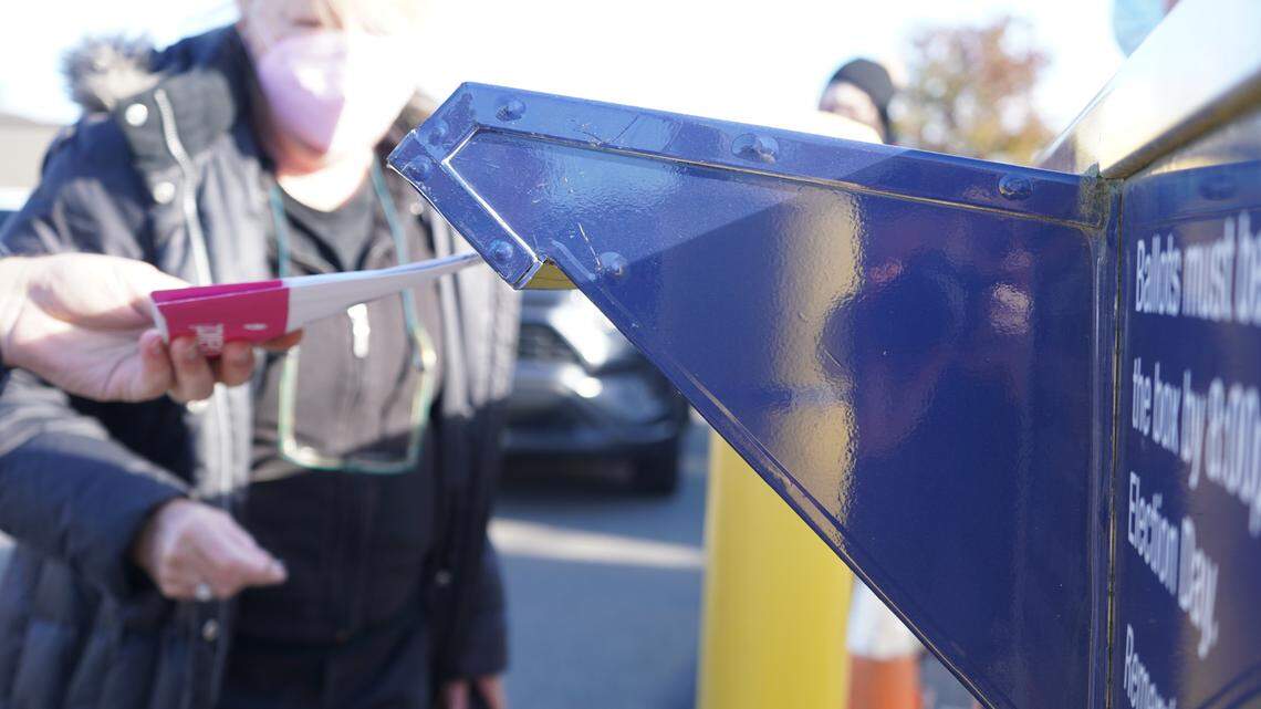 A voter drops their ballot in an official drop box near the Whatcom County Courthouse on Election Day in November 2022.