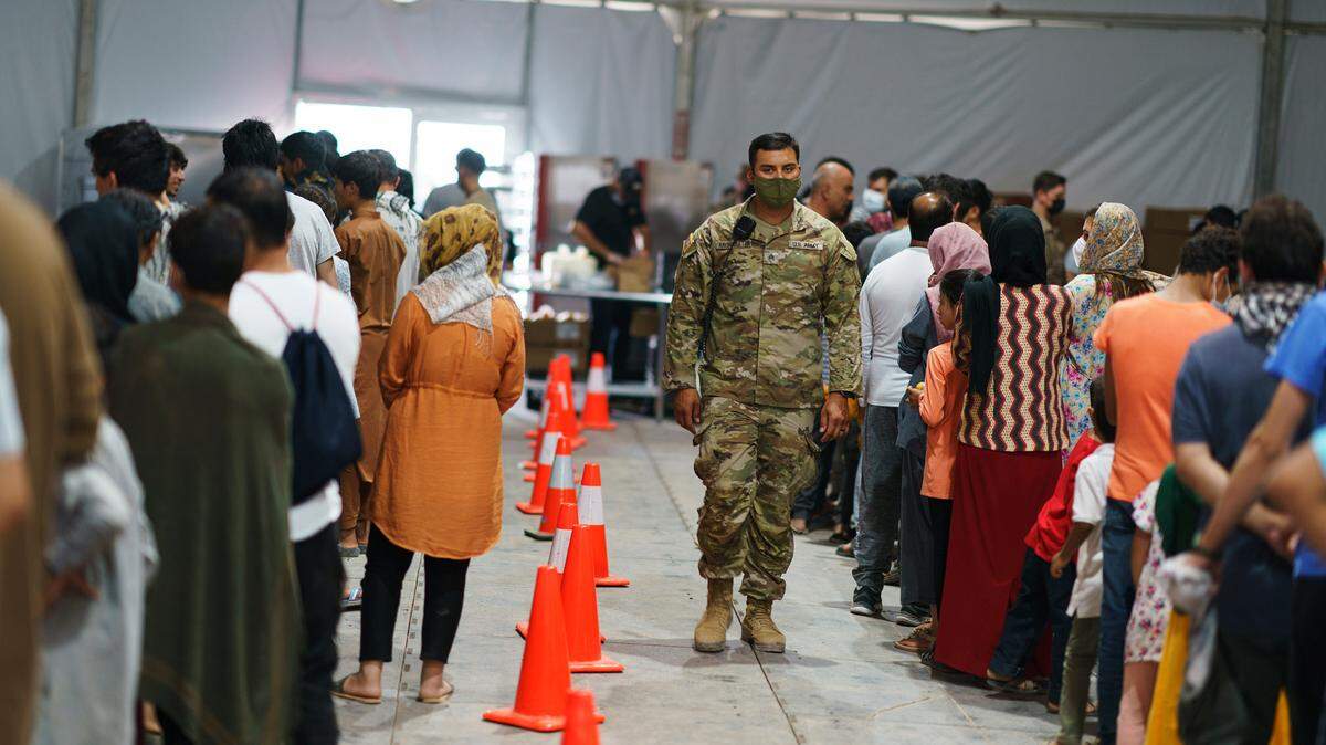 Afghan refugees line up for food in a dining hall in New Mexico.