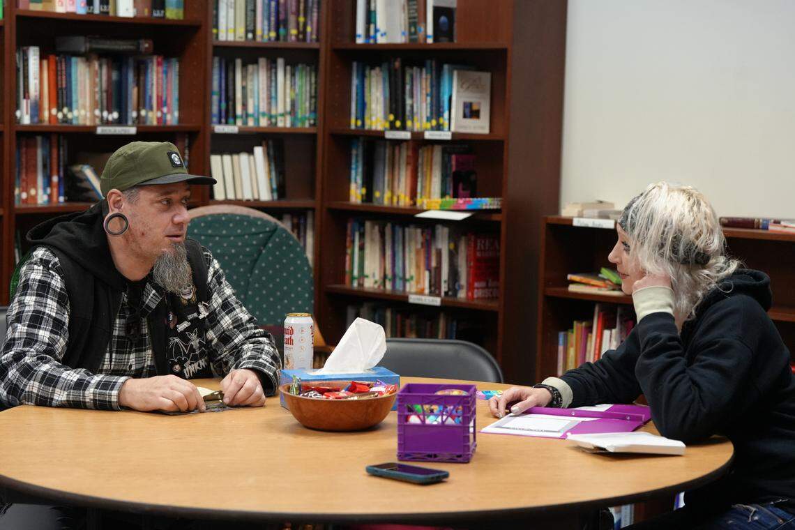 Amy Kenna and Jeremy Bowers speak to each other in the Recovery Circle room at the Recovery Café.