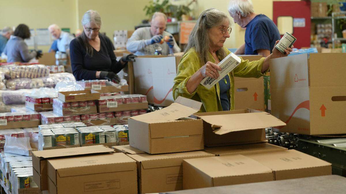 Volunteers package boxes with staple food items at the Bellingham Food Bank on April 24 in Bellingham.