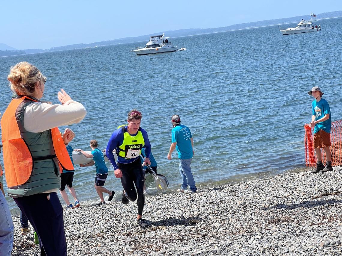 Aaron Small, the sea kayaker for Evil Bike Co, races up the beach toward the finish line at Marine Park in Bellingham, Wash. on Sunday, May 28, 2023. Evil’s team finished sixth overall in the 50th annual Ski to Sea race.