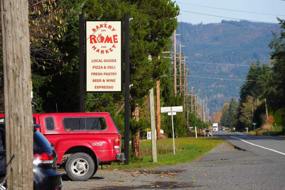A sign on the Mt Baker Highway advertises locally-made goods, pizza, deli food, pastries, beer, wine and espresso at Rome Bakery and Market on November 11, 2025, in Bellingham, Wash.