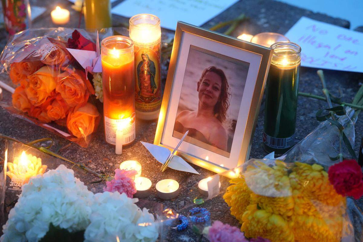 A framed image of Renee Good, a Minneapolis resident who was shot and killed by ICE agents, is surrounded by flowers and candles at an anti-ICE vigil at Western Washington University.