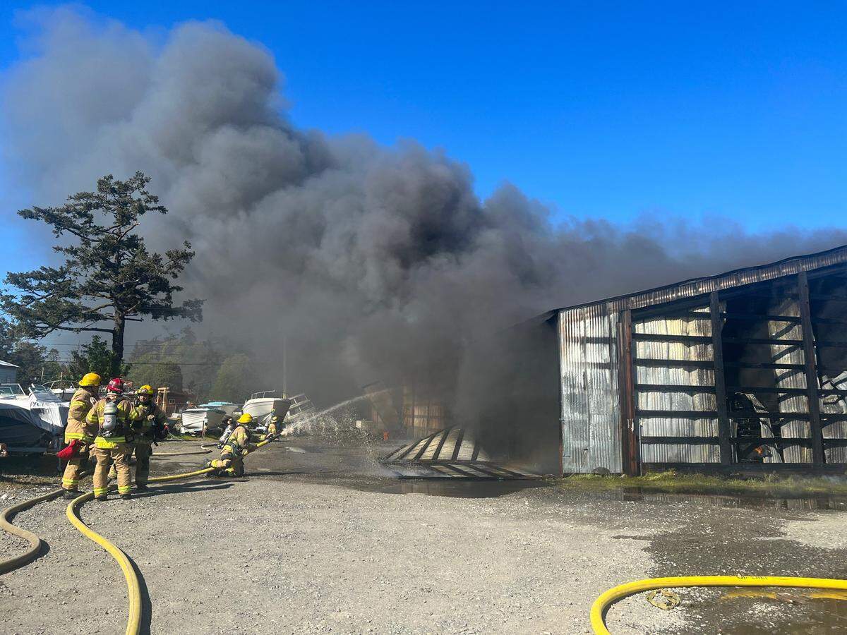 Firefighters battle a fire at a boatyard on Gooseberry Point near Bellingham on Tuesday, April 10. The fire destroyed a building and the boats and fishing gear stored inside, causing an estimated $2.5 million in damage, but no serious injuries were reported.