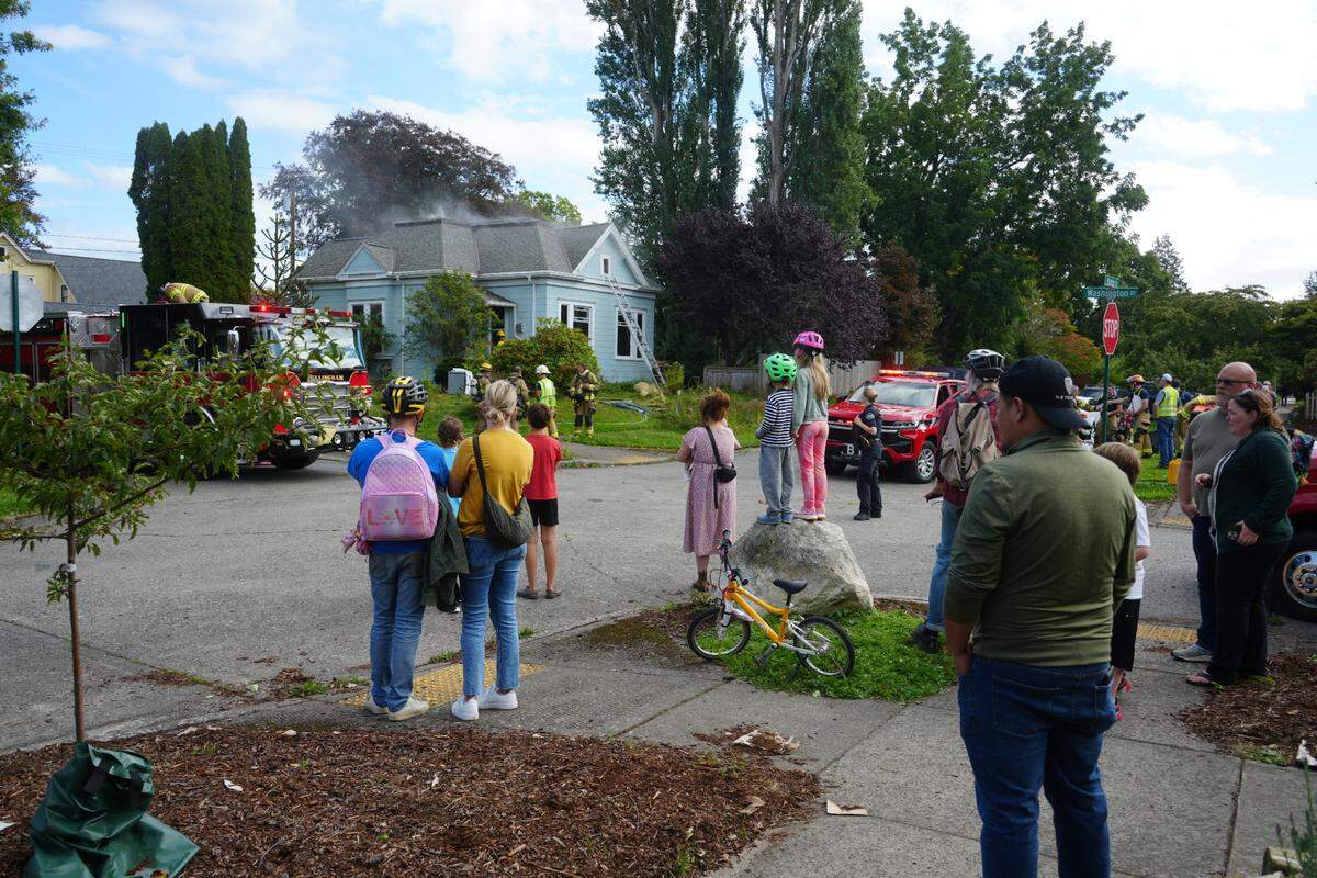 Neighbors watch as Bellingham Fire Department crews respond to a house fire at 2230 Victor Street just after 2:30 p.m. on September 27, 2024, in Bellingham, Wash.