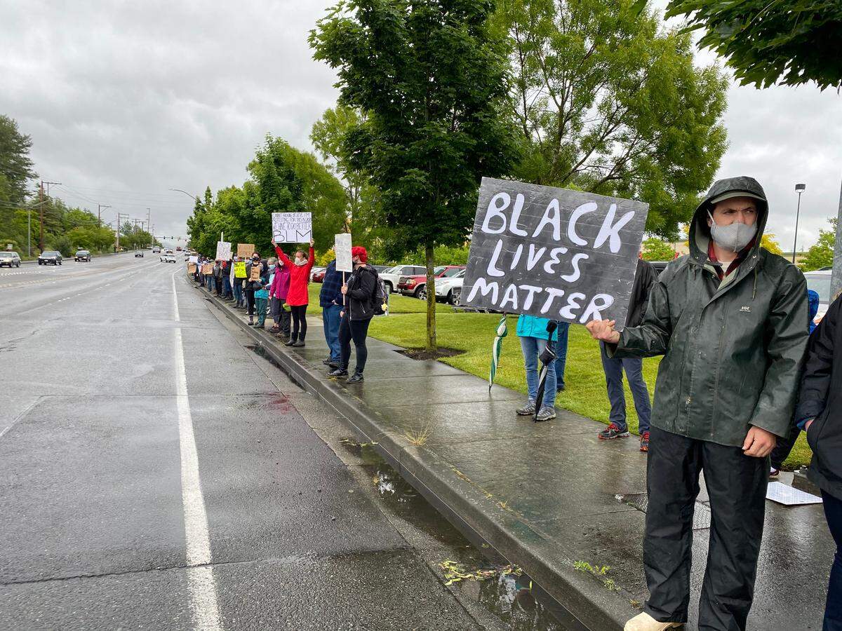 Protesters line the sidewalks at a protest against racial injustice and inequality experienced by people of color Friday afternoon, June 12, at the intersection of West Bakerview Road and Arctic Avenue in Bellingham.