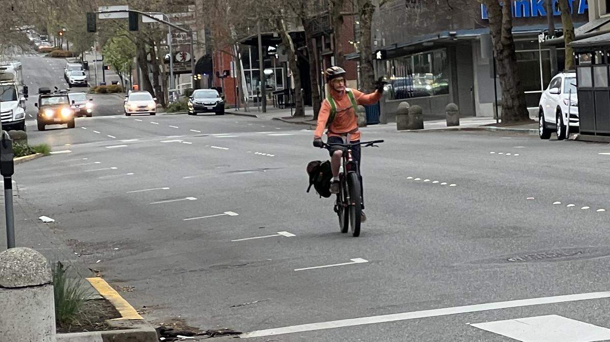 A bicyclist turns from Holly Steet onto Commercial Street ahead of commuter traffic on Monday, April 8, 2024, in downtown Bellingham, Wash.