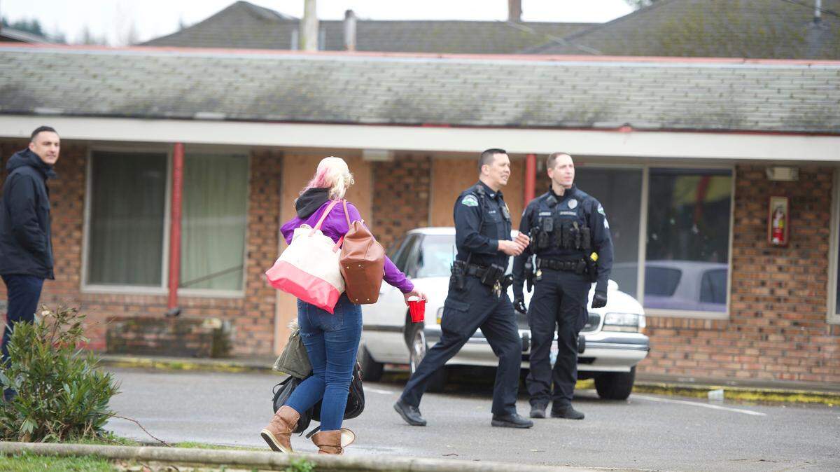 Bellingham Police officers watch Tuesday as trespassers leave the Villa Inn at 212 N. Samish Way in Bellingham. City crews boarded up unoccupied rooms at the inn that is being sold and will be demolished for apartments.