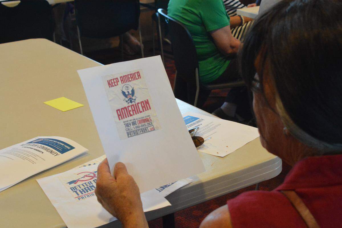 NapéWastéWiñ of Ferndale examines Patriot Front flyers that were posted in downtown Ferndale during the “Not in Our Community!” at the Ferndale Library on Tuesday, Aug. 27, 2019.