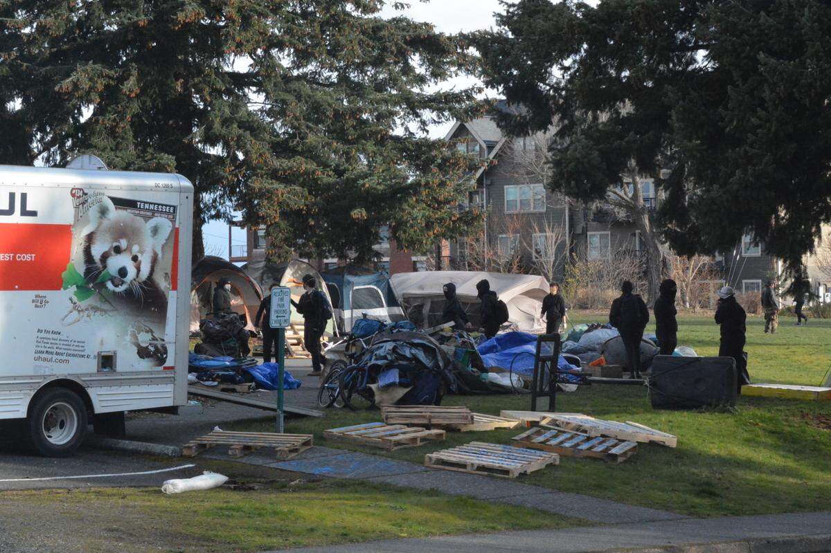 Homeless people pack their belongings after being told to leave an encampment at Laurel Park in Bellingham Friday, March 19.