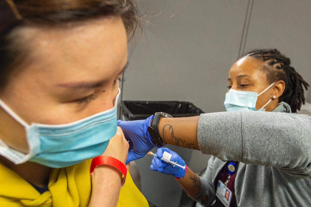 Licensed practical nurse Ivory Royal administers the second shot of the Pfizer COVID-19 vaccine to Piyada Kuankitpaisam of Bellingham on Feb. 20 at PeaceHealth St. Joseph Medical Center in Bellingham. The vaccine clinic was held for hospital employees.