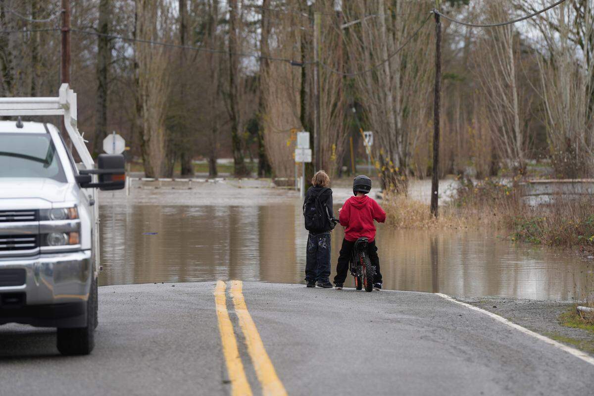 The Nooksack River flooded Washington Street on December 10, 2025, in Ferndale, Wash. Residents on the street prepared to leave their homes as a voluntary evacuation order was issued.