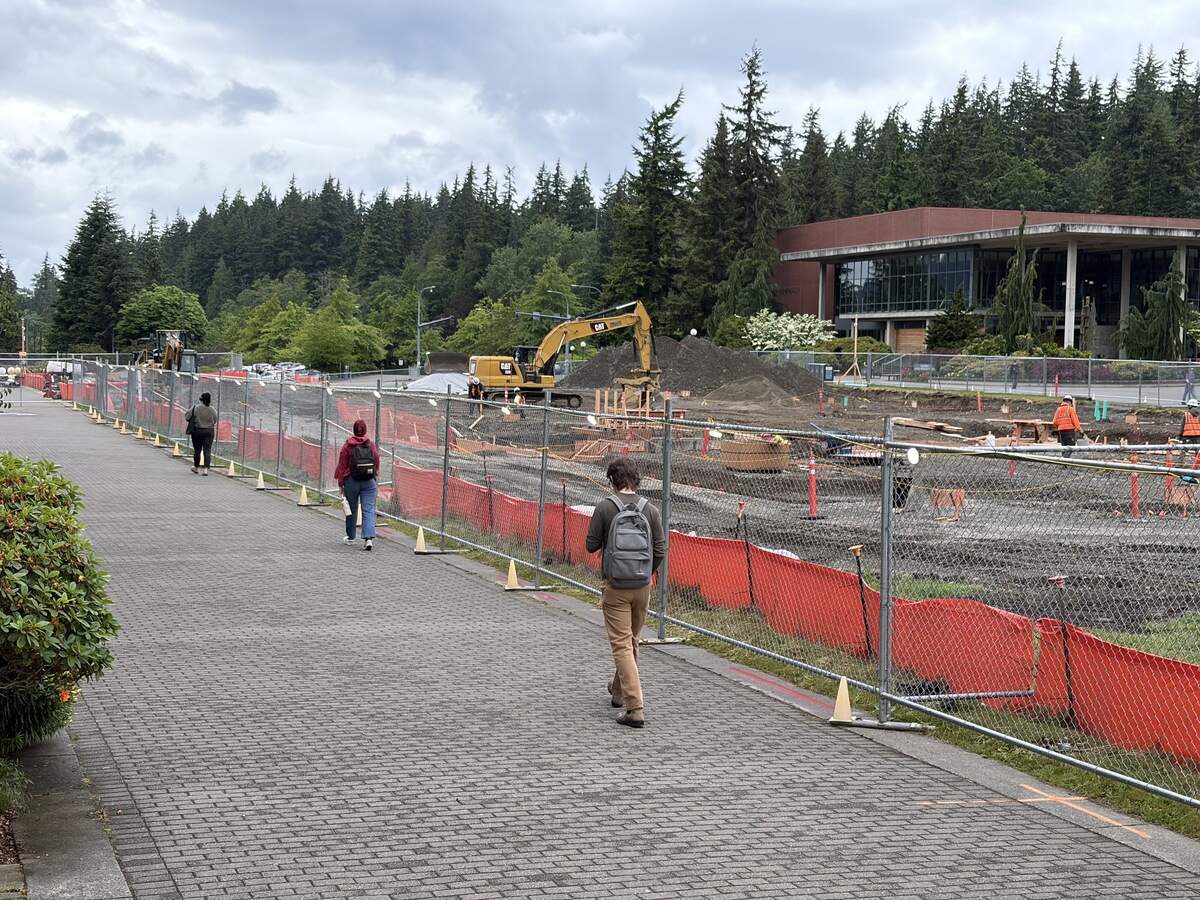 Students walk by the construction site of Western Washington University’s future Western Welcome Center building on June 5.