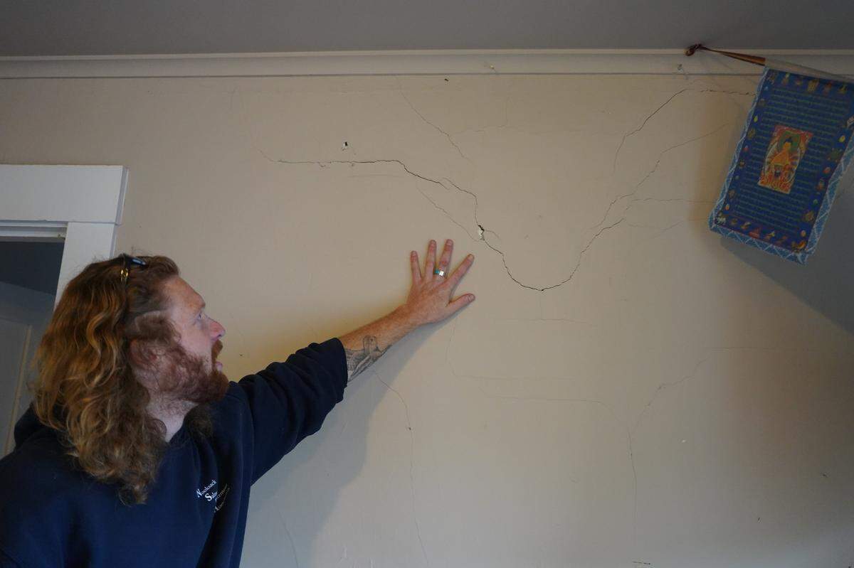 Aidan Hersh points out a cracked wall in his rental unit in 2023.