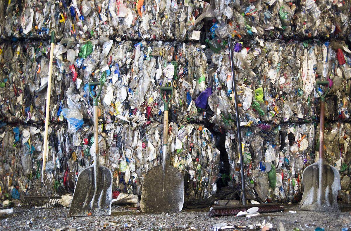 Shovels, a rake and a broom used for cleanup lean against stacked bales of plastic at Northwest Recycling, Inc. in Bellingham.