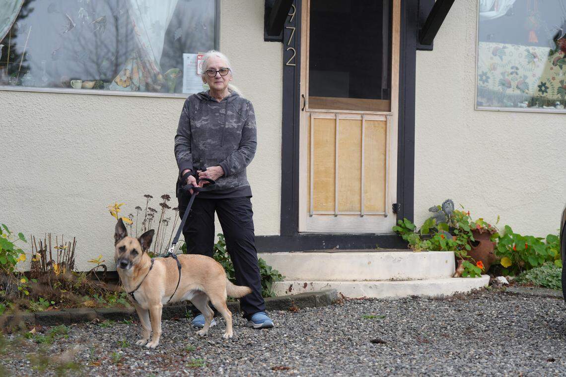 Charlette Seaver and her dog, Arlo, prepare to leave their home on Washington Street amid rising Nooksack River floodwaters on December 11, 2025, in Ferndale, Wash. The city was under voluntary evacuation orders.