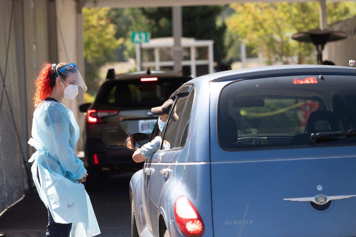 People wait to be tested for COVID-19 at a testing site operated by Northwest Laboratory at Bellingham International Airport on Thursday, Sept. 2.