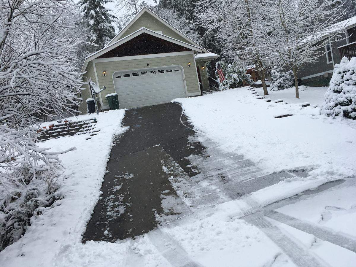 A driveway is shoveled and sprinkled with ice-melt, which will clear snow and ice.