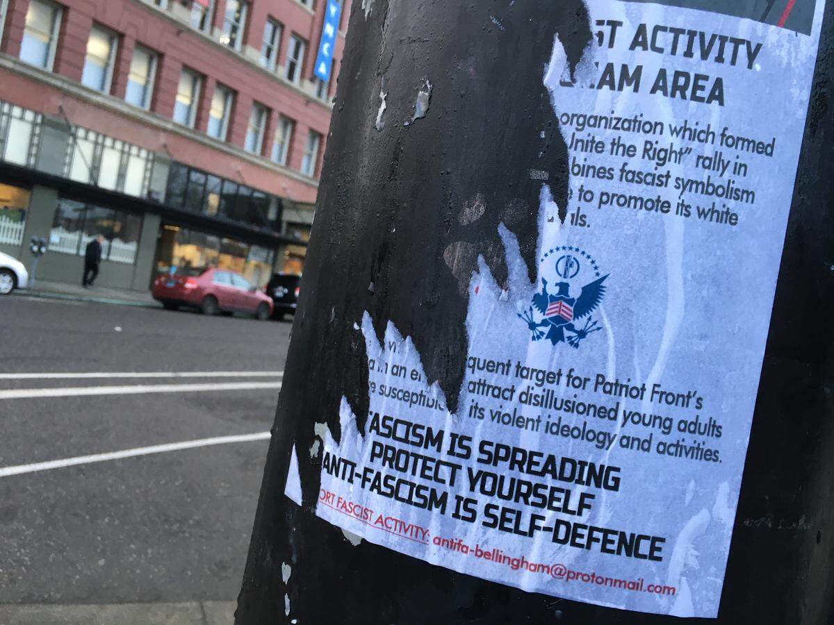 A defaced poster on a downtown Bellingham traffic signal pole Feb. 13 warns about the Patriot Front, a white supremacist group.