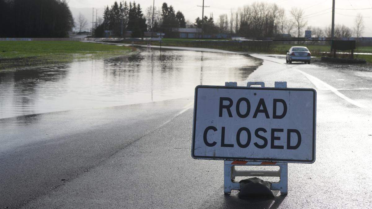 A sign indicates the closure of Hannegan Road on Dec. 9, 2025, due to flooding over the roadway near Lynden, Wash.