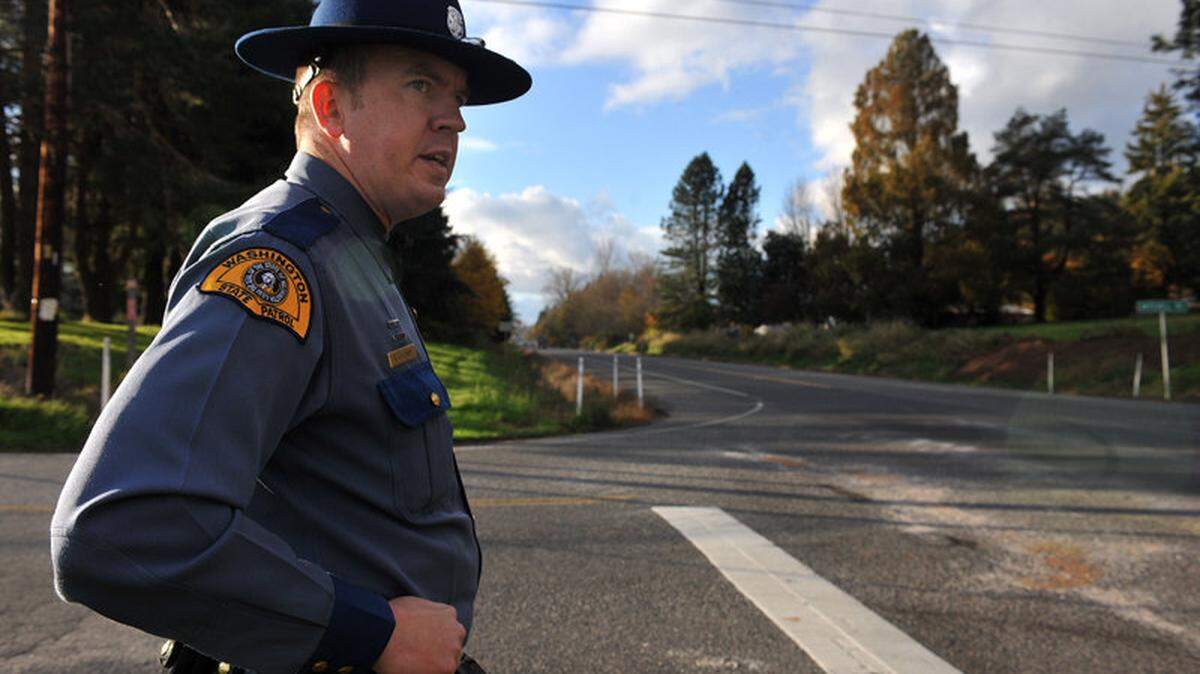 In this 2010 file photo, Washington State Patrol Trooper Keith Leary examines the road at the corner of Mount Baker Highway and Mitchell Road in Deming, the scene of a car wreck that claimed the life of Mount Baker High School student Kourtney Cadle earlier that year.
