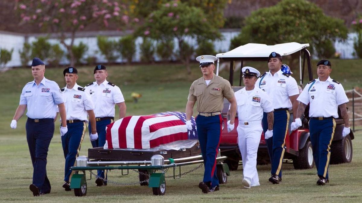 Military pallbearers escort the exhumed remains of unidentified crew members of the USS Oklahoma killed in the 1941 bombing of Pearl Harbor that were disinterred from a gravesite at the National Memorial Cemetery of the Pacific in July, 2015 in Honolulu. The Pentagon hopes to identify the rest of the Oklahoma’s “unknowns,” now estimated to be about 388.