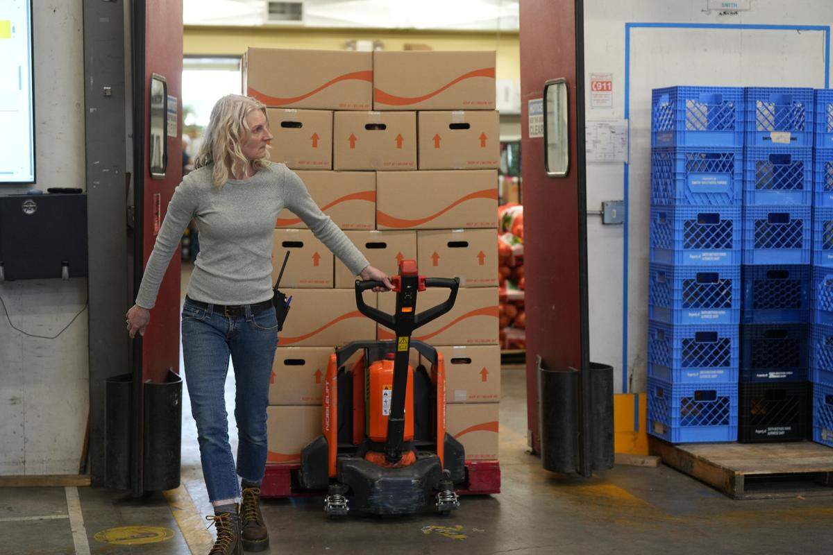 A Bellingham Food Bank staff member delivers a shipment of packaged food to a delivery truck in April.