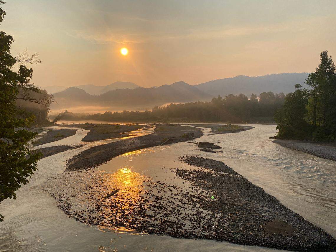 The sun rises above the Nooksack River on a smoky morning on Thursday, Aug. 12, 2021, in Whatcom County.