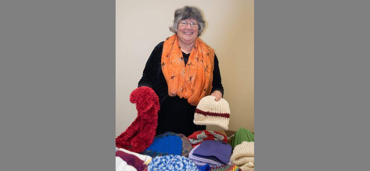 Ronalee Kincaid, coordinator for Project Warm-Up, with hats and scarves created by volunteers throughout Whatcom County for those who need them.