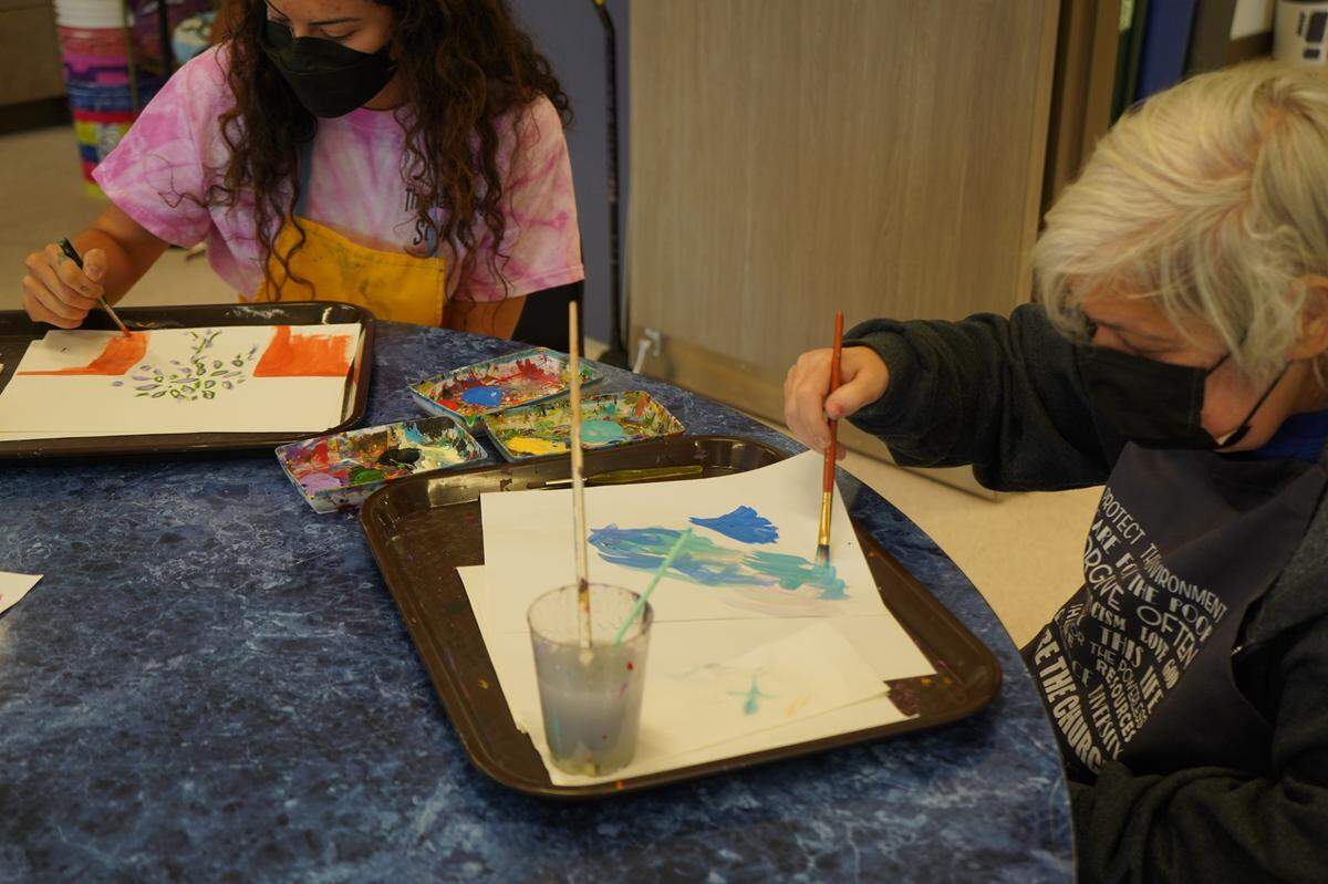 Max Higbee Center Community Connections Coordinator Ronnie Delgado, left, paints with a Max Higbee Center member, at the new facility on Thursday, Sept. 15, in Bellingham.