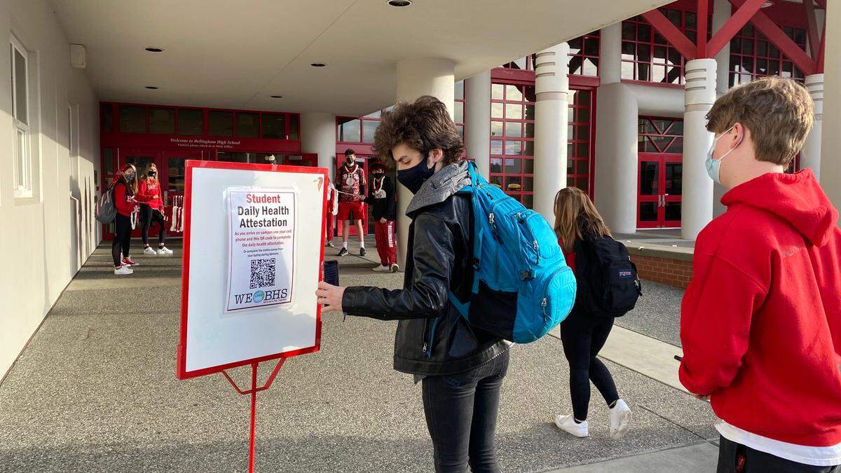 A student scans a Daily Health Attestation QR code upon arriving for in-person classes at Bellingham High School on Friday, March 26.