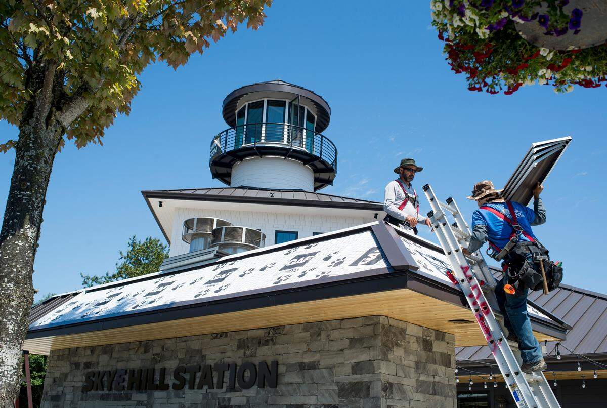 Mount Baker Roofing employees Benigho Rayo, right, and Daniel Rodriguez install a roof at Skyehill Station on Wednesday in Blaine.