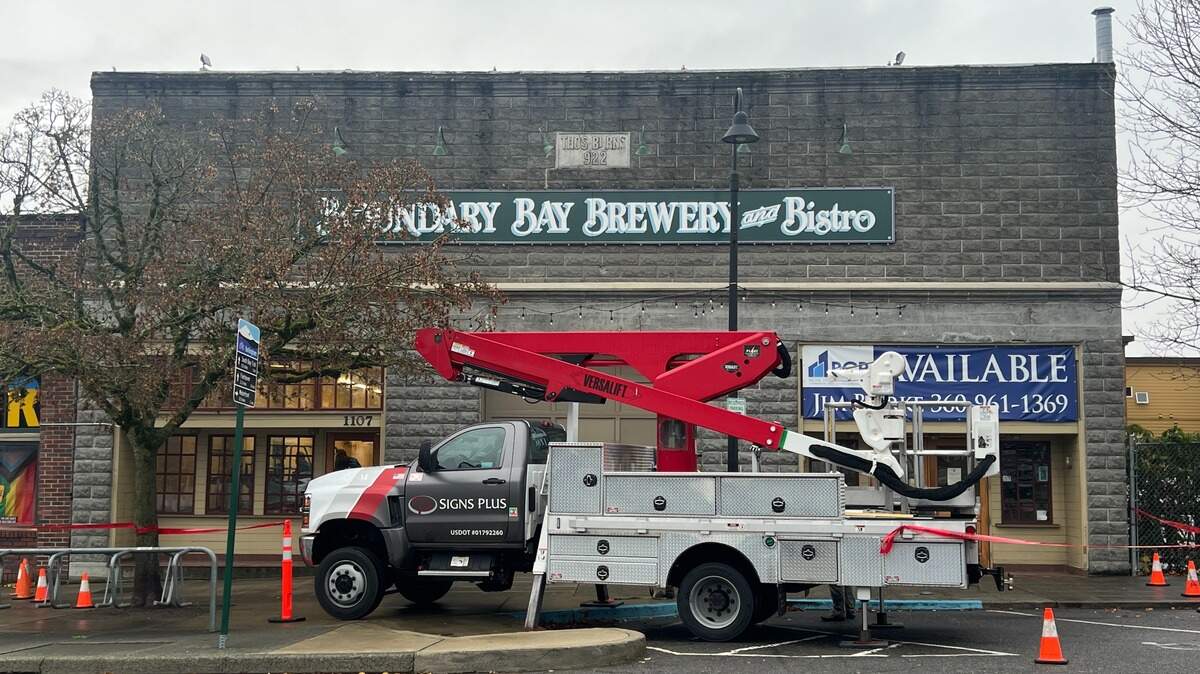 Workers from Signs Plus get ready to remove the iconic Boundary Bay Brewery sign from the former brewpub at 1107 Railroad Ave. in Bellingham on Friday, Nov. 14, 2025. 