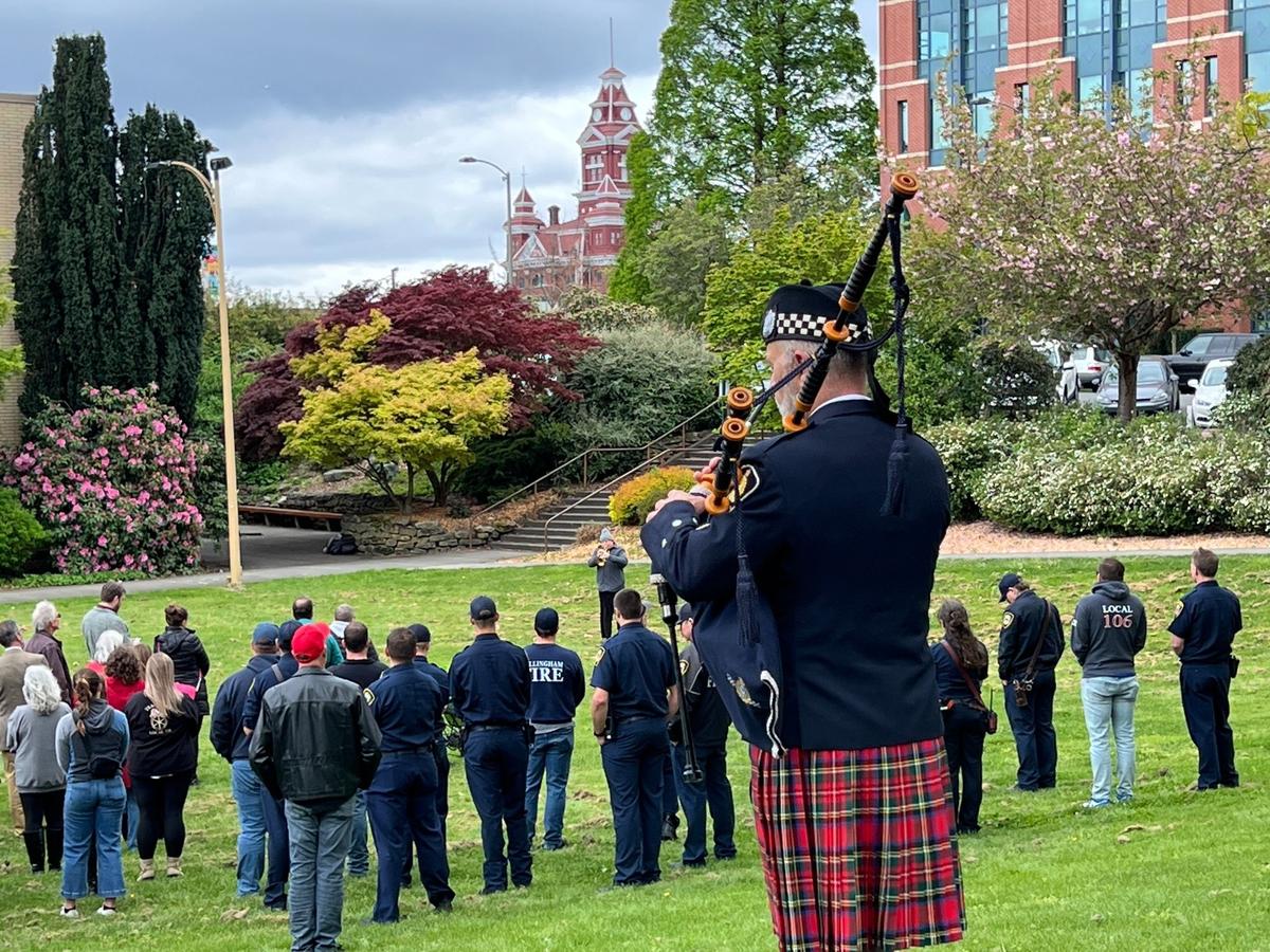 Wayne Rodgers of Bellingham, with the Vancouver (B.C.) Police Pipe Band, watches as a bugler plays taps at the close of the Worker Memorial Day ceremony at Lee Memorial Lawn in Bellingham on Monday.